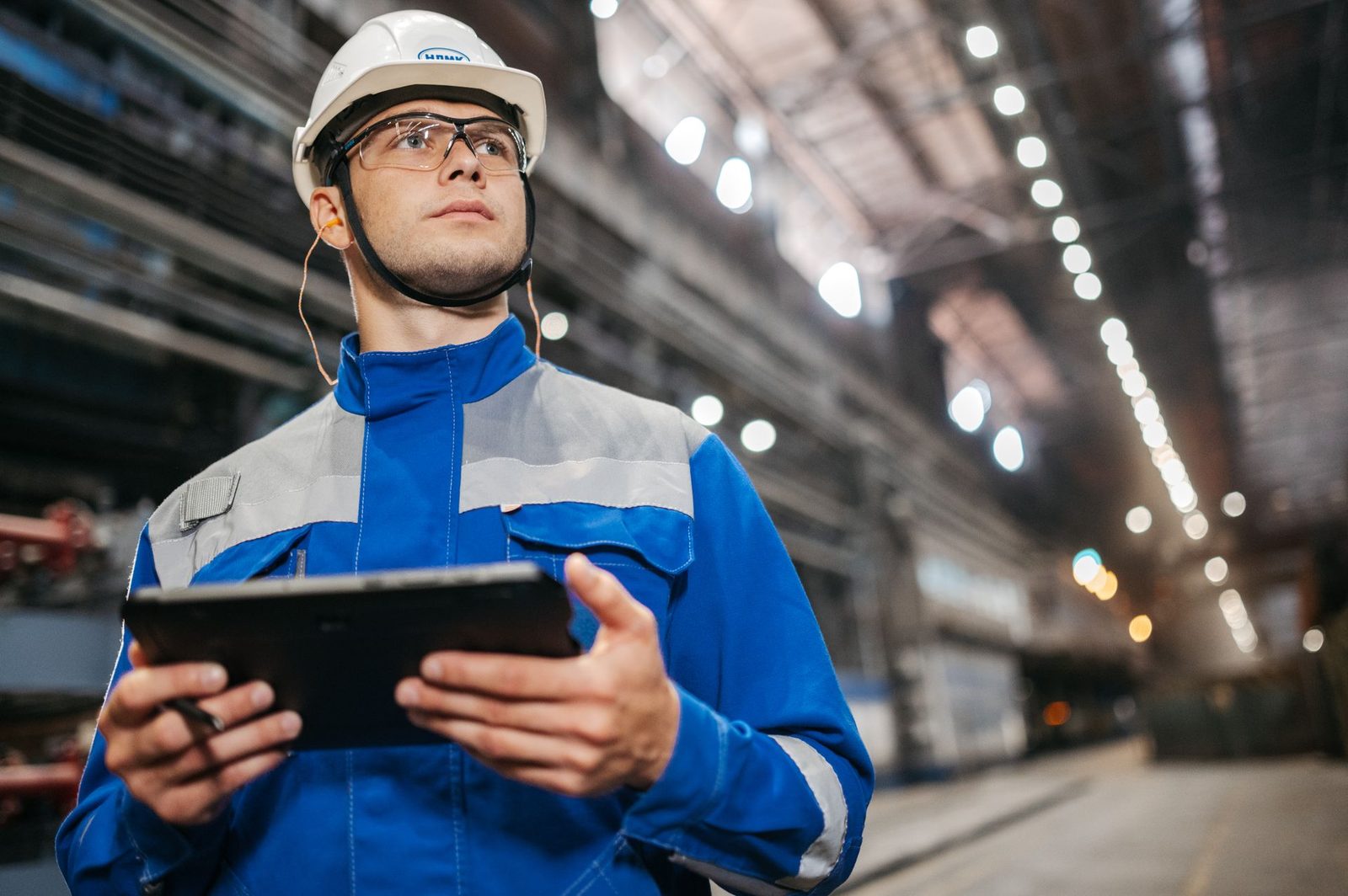 Industrial professional using a tablet to track crew credentials and schedules