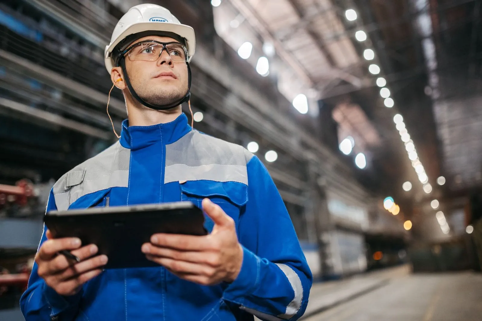 Industrial professional using a tablet to track crew credentials and schedules